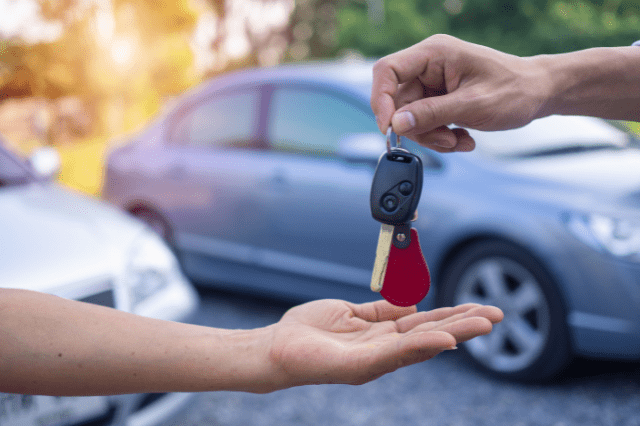 man handing keys to woman
